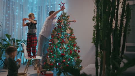 Father-and-son-dress-up-together-Christmas-tree.-Christmas-decorations-for-the-Christmas-tree-the-family-decorates-the-Christmas-tree-together.-High-quality-4k-footage